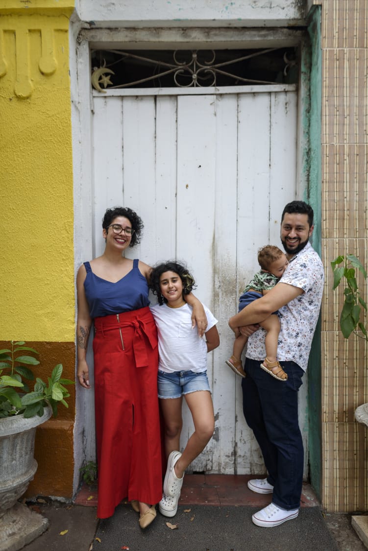 Fam&iacute;lia posa em frente porta de escolinha que L&iacute;gia estudou quando era crian&ccedil;a