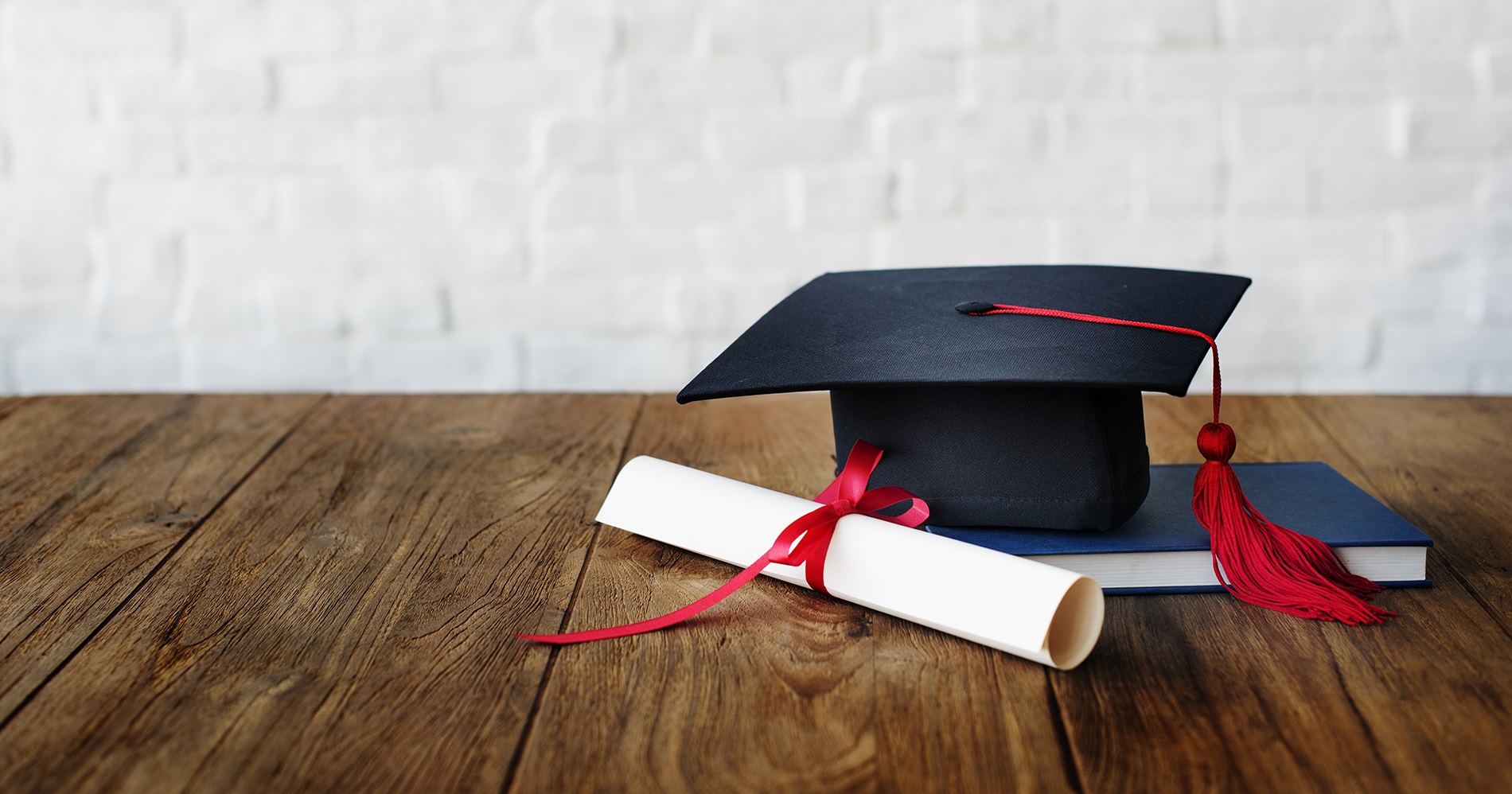 Diploma e capelo de formatura e formandos