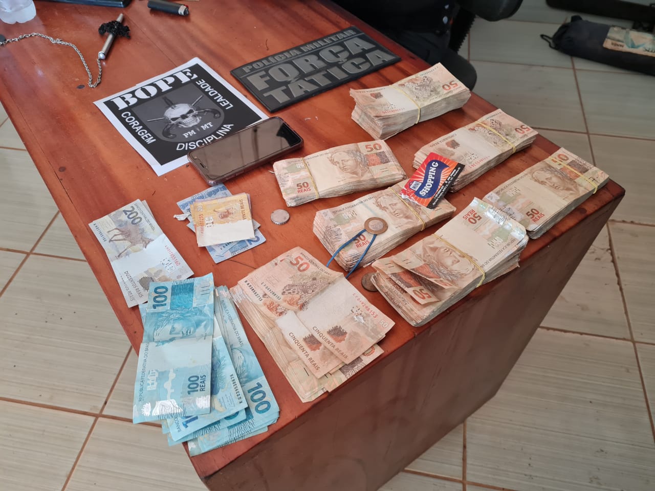Dinheiro e armas apreendidas com suspeitos mortos